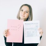 woman holding a pink paper offering service on tax forms